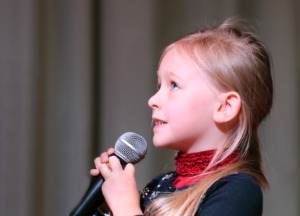 A young girl taking singing lessons