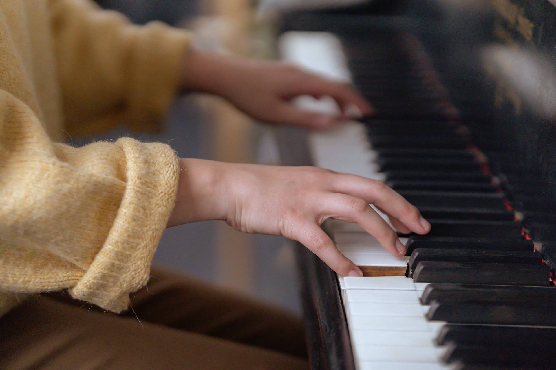 A woman taking adult music lessons to learn how to play piano