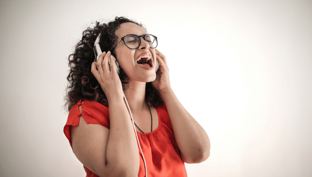 Une femme chante chez elle avec un professeur lors de son cours de chant en ligne