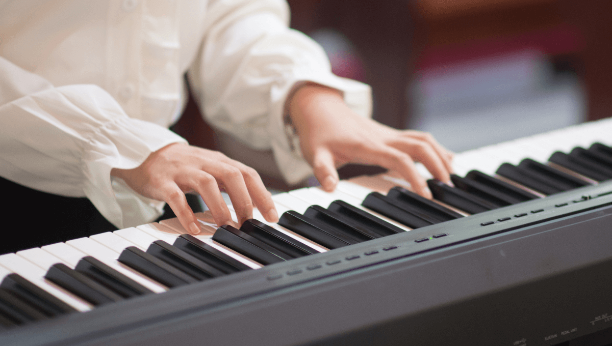 Un étudiant prend un cours de piano en ligne depuis son domicile