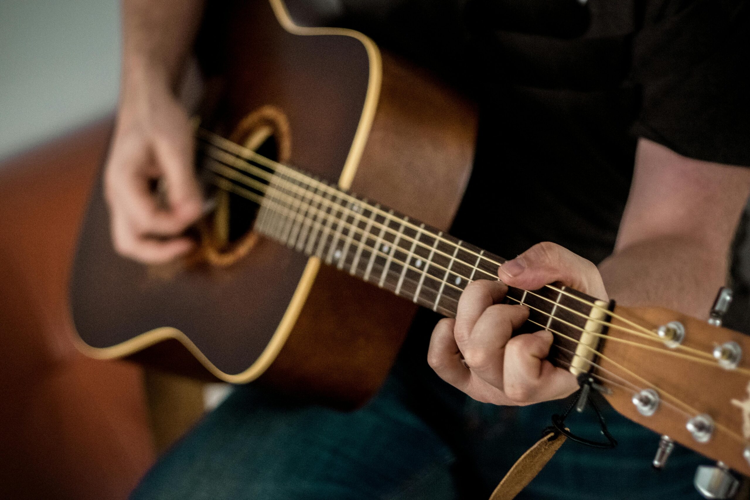A close-up view of a guitar resting on a stand inside a well-lit room, symbolizing learning guitar through tabs.
