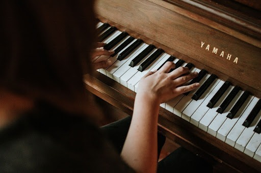 Main d'un élève jouant du piano sur un piano Yamaha lors d'un cours de musique à Montréal