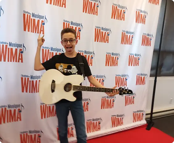 Music student posing with guitar at a West Island Music Academy event