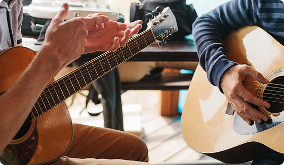 WIMA guitar teacher helping a beginner with chords in Pointe-Claire.