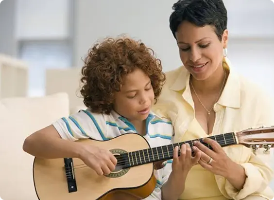 WIMA guitar teacher helping a beginner with chords in Pointe-Claire.