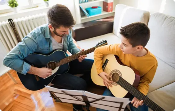 WIMA guitar teacher helping a beginner with chords in Pointe-Claire.